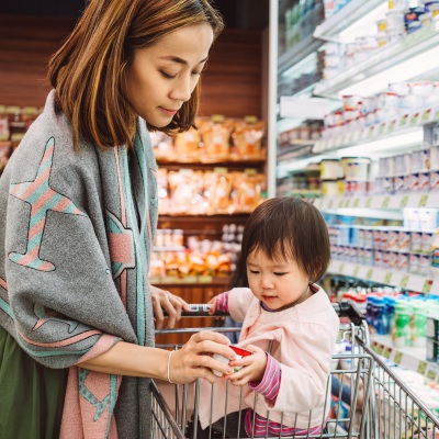 Asian mom and baby at grocery | GettyImages, TangMingTung