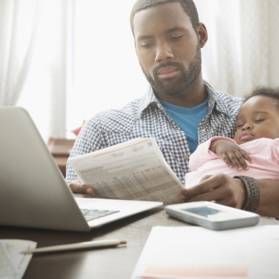 Father holding baby daughter and working | Jose Luis Pelaez INC