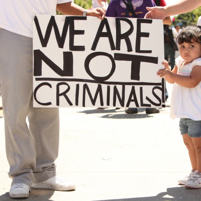 Immigrant child holding sign | Shutterstock, tobkatrina