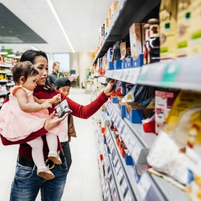 Mom holding child while shopping | Getty Images | Tom Werner