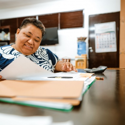 Differently abled Filipino woman reading documents | Getty Images