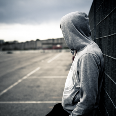 Young man along fence_zodebala | Getty Images