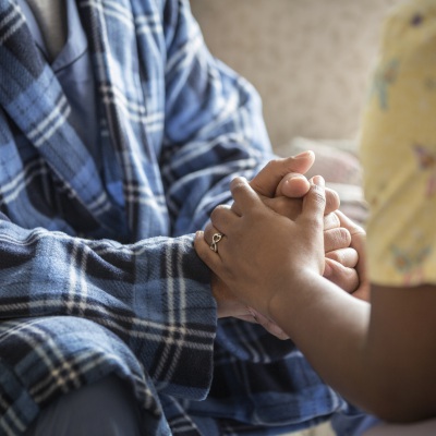 caregiver and patient hold hands | Terry Vine | Getty Images