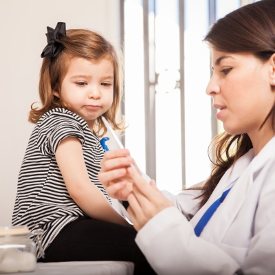Doctor giving check up to young child | Shutterstock, Antonio Diaz