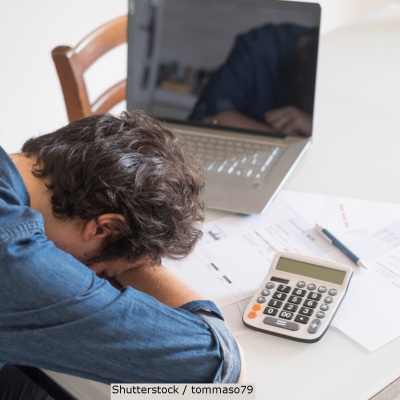 Man struggling with taxes | Shutterstock, tommaso79