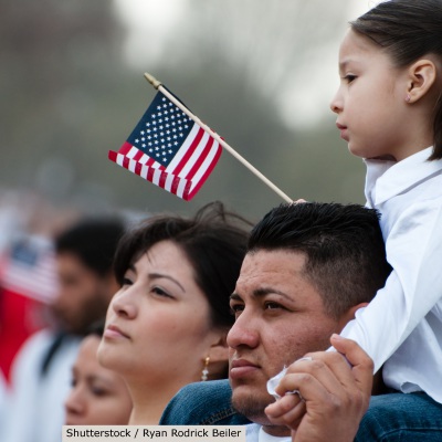 Young Hispanic girl holding flag | Shutterstock, Ryan Rodrick Beiler