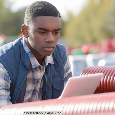 Young man studying tablet at work site | Shutterstock, Alpa Prod