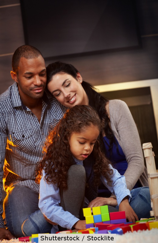 Parents playing with young child | Shutterstock, StockLite