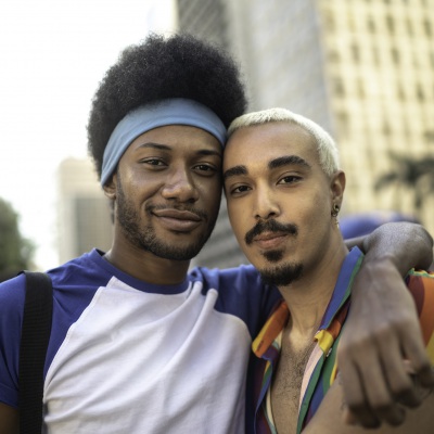 Male couple embracing during LGBTQI parade | Getty Images | FG Trade