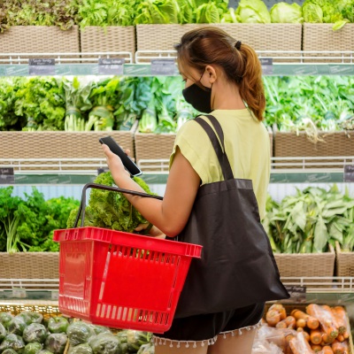 Woman grocery shopping for green vegetables