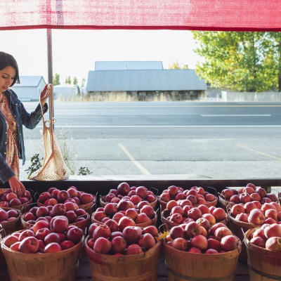 Young woman at farmers market | Getty Images