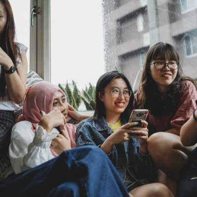 Group of AAPI women drinking tea or coffee and laughing