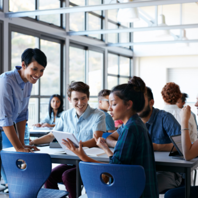 Teacher assisting group of students in classroom