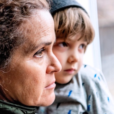 Caucasian Mature woman posing with her son, very sad looking through window worried about loss of her job due Covid-19 pandemic used in a blog about a Better Poverty Measure