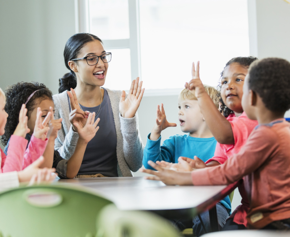 Multi-ethnic preschool teacher and students in classroom