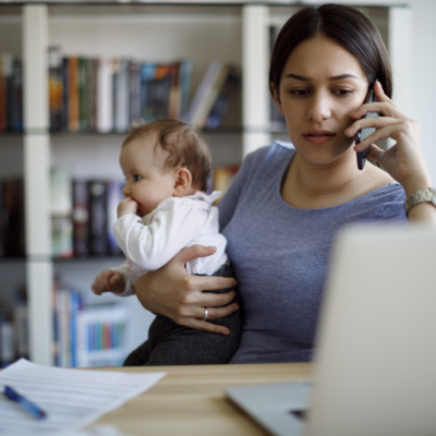 Worried mother using mobile phone an laptop at home