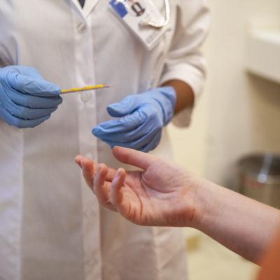 Gloved health care worker treating patient