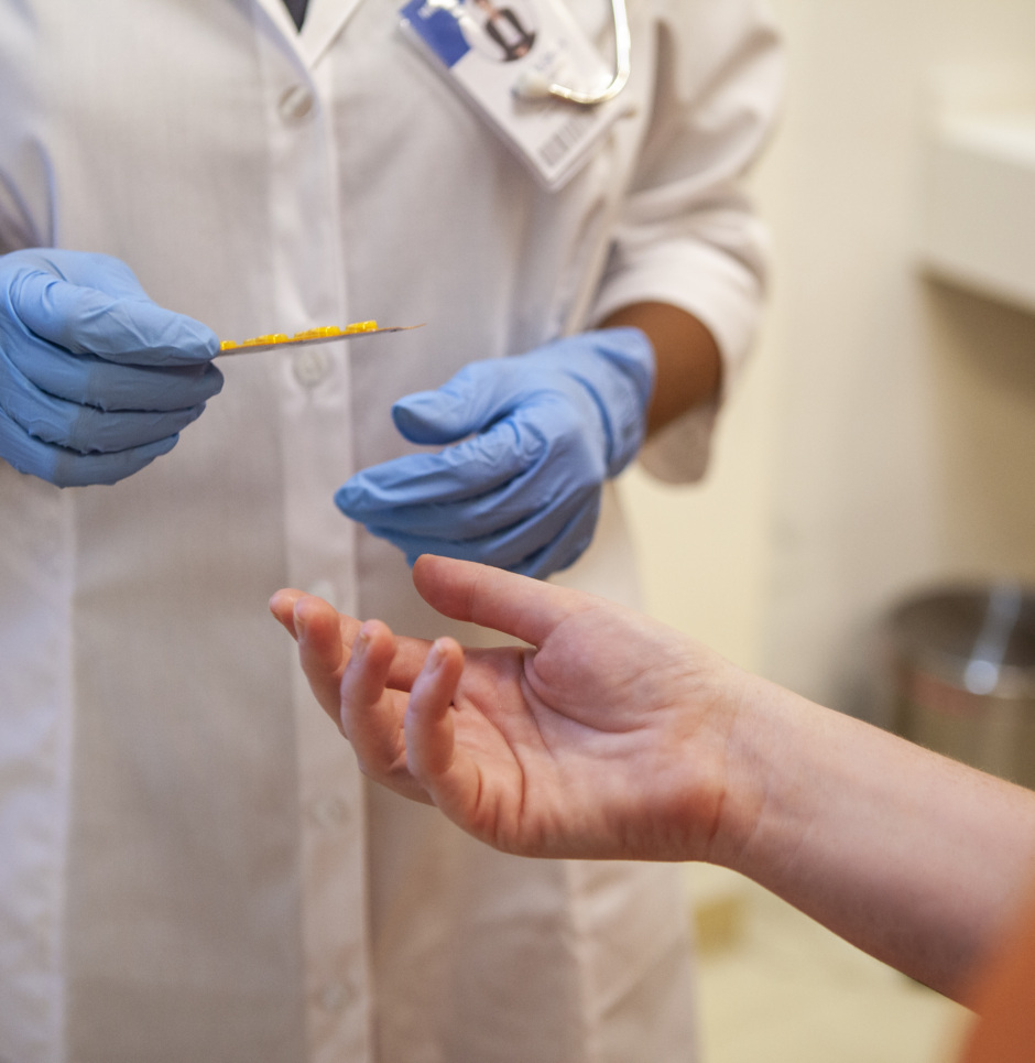 Gloved health care worker treating patient